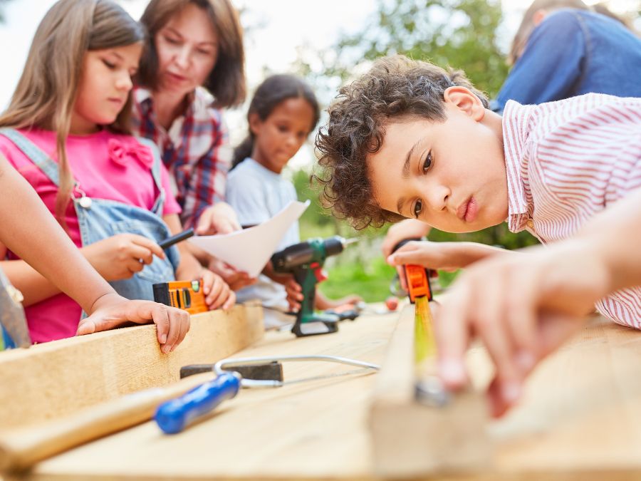 Children and adults working with tools and wood.
