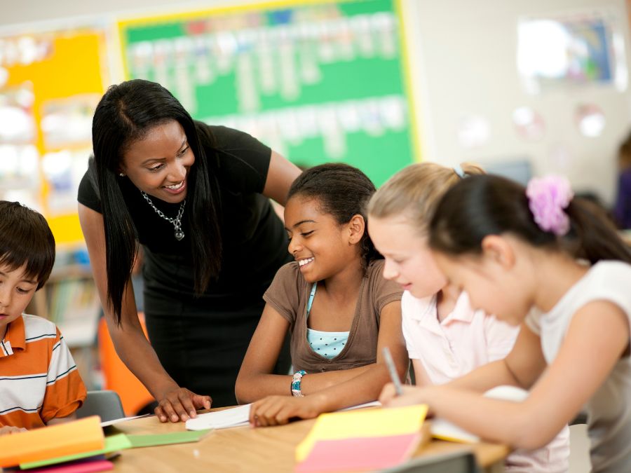 Teacher helping students on classwork.