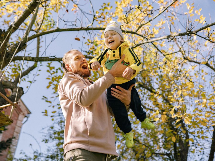 Fathering playing with baby outside.