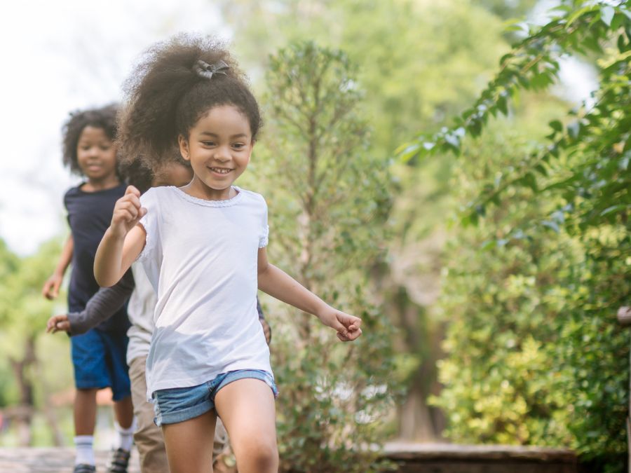 Three children running outside.