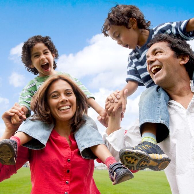 Two parents and two children playing outside.