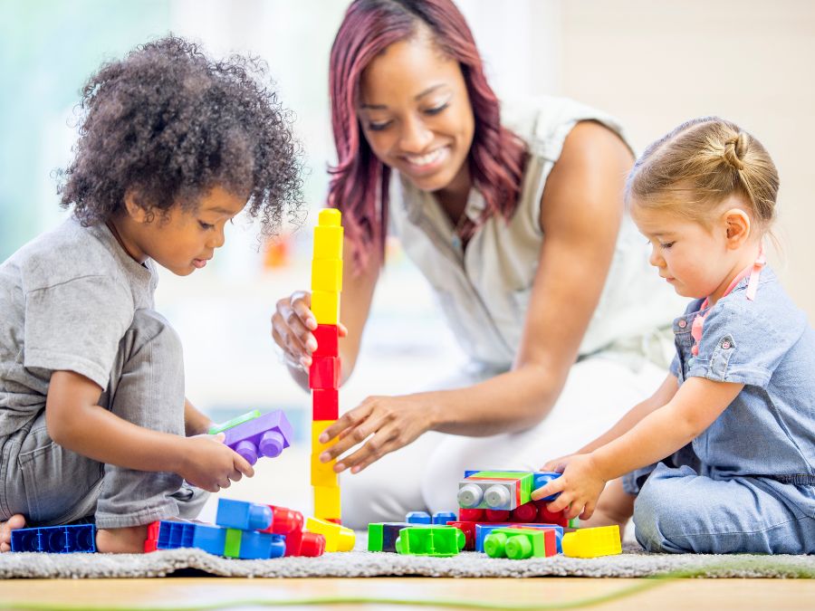 Teacher playing with blocks with two young children.