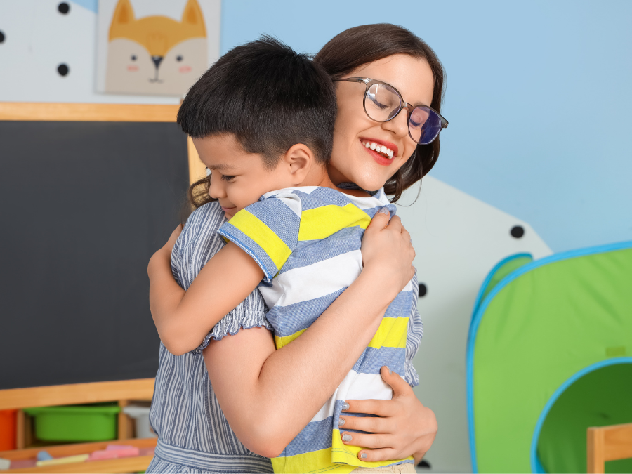 teacher and child hugging