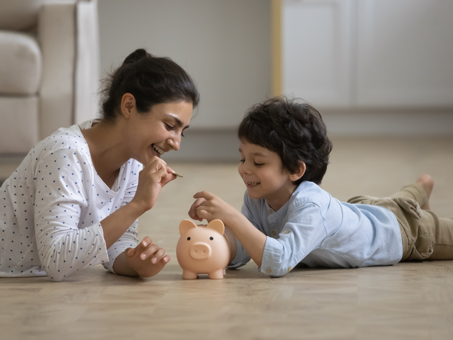 Parent and child putting coins in a piggy bank.